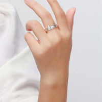 Hand wearing a cute sterling silver demon horn ring with cute face