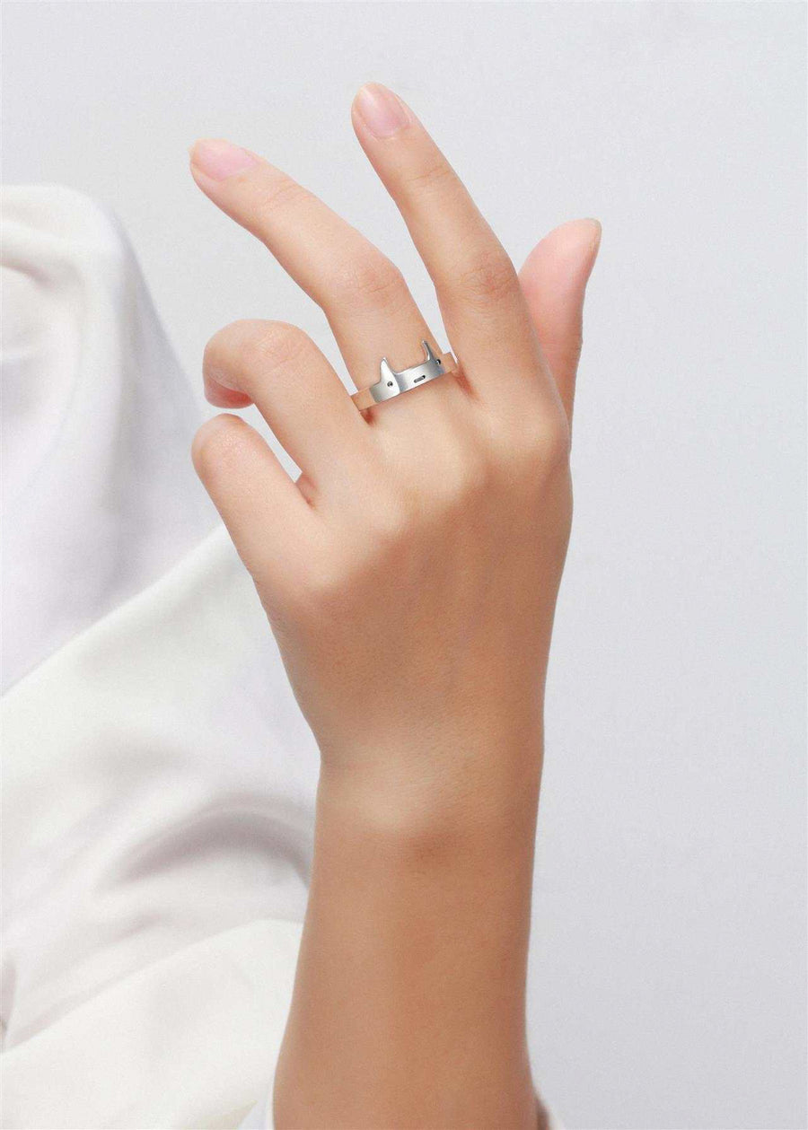 Hand wearing a cute sterling silver demon horn ring with cute face